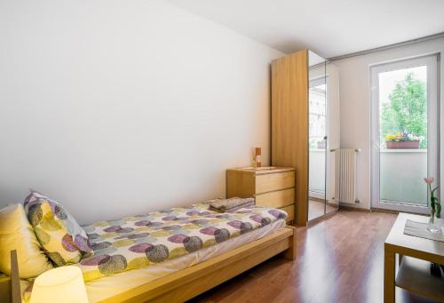 布达佩斯可爱考文公寓的一间卧室配有一张床、一个梳妆台和一扇窗户。