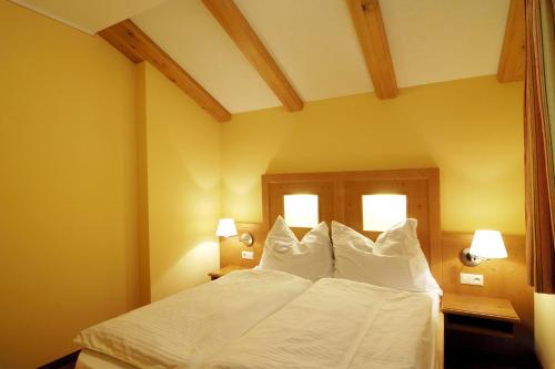 HüttschlagHaus Alpenquell的一间卧室配有带白色床单和枕头的床。