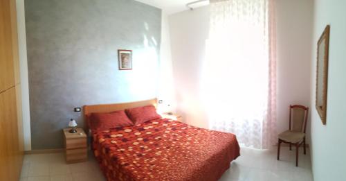 维耶斯泰Villa Lucrezia Trilo的一间卧室配有一张带红色棉被的床和窗户。