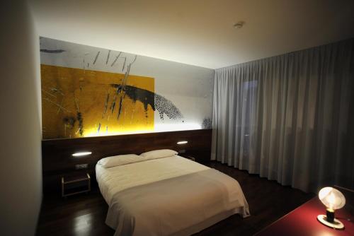卡奥莱开里娜安格酒店及酒馆的卧室配有一张床,墙上挂有绘画作品
