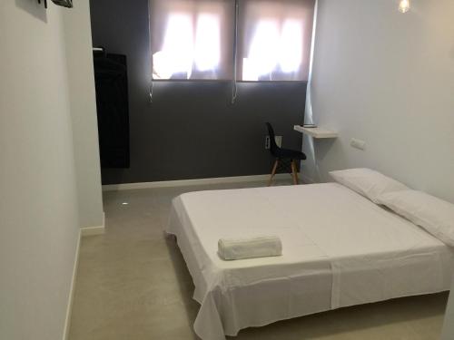 多列毛利诺斯太阳客房宾馆（拉诺加雷拉广场）的卧室配有白色的床和2扇窗户。