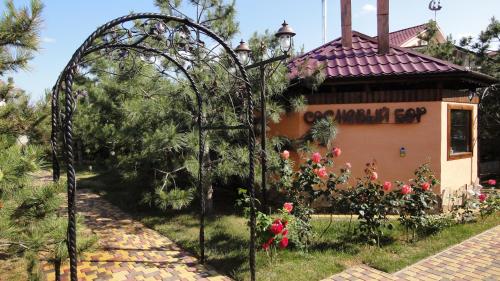 扎托卡Villa Sosnovy Bor的鲜花盛开的建筑前的花园拱门