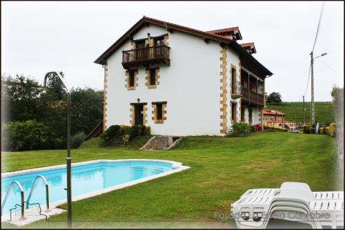 Toñanes拉埃斯特拉坎塔布莱波萨达酒店的一座房子前面设有游泳池