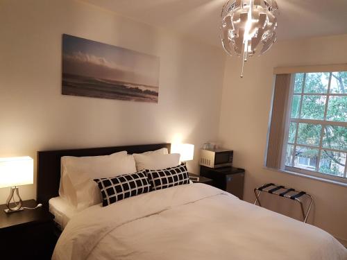 黎明城萨瓦草度假屋的一间卧室配有一张床、两盏灯和吊灯。