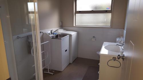 罗托鲁瓦罗托鲁瓦美景公寓/住宿加早餐旅馆的一间带水槽和洗衣机的小浴室