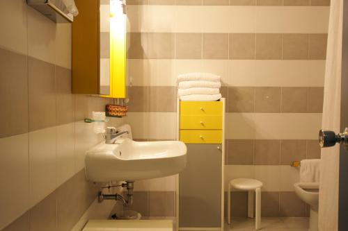 蒂勒尼亚高尔夫大酒店的一间带水槽和黄色橱柜的浴室