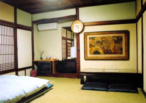 东京塔玛日式旅馆的卧室配有一张床,墙上挂着一个钟