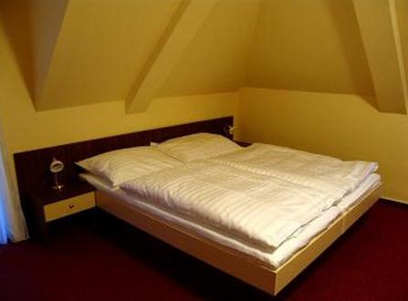 斯泰尔霍伊阿尔滕贝格酒店的一张小床,位于一个黄色墙壁的房间