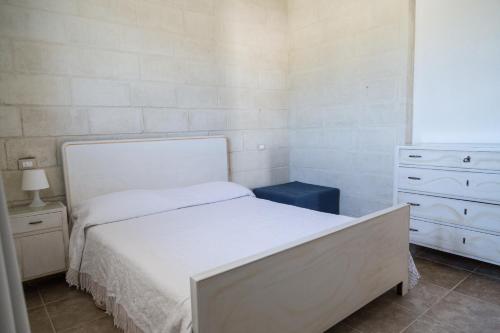 拉泰尔扎Masseria 25 Anni的一间小卧室,配有白色的床和梳妆台