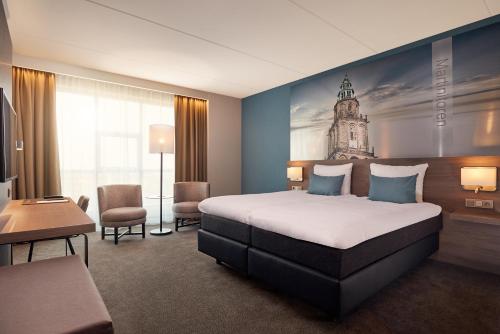 格罗宁根凡沃克格罗宁根霍克酒店的酒店客房设有一张床,墙上设有钟楼