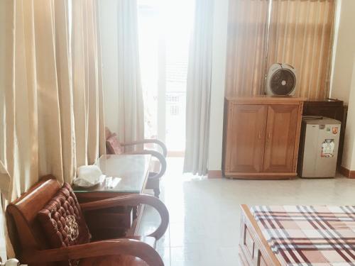 芽庄Chang Homestay的客厅配有椅子、桌子和窗户