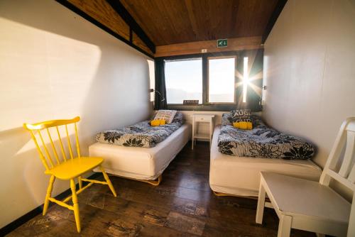 Haukadalur歌瑟尔海斯塔尔旅舍的小房间设有两张床和椅子