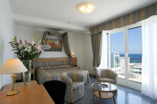 阿拉西奥美帝特拉奈大酒店的酒店客房设有一张床和一个海景阳台