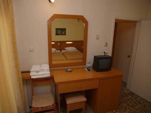 伊里斯斯Hotel Markos的一间卧室配有一张带镜子的桌子和一台电视