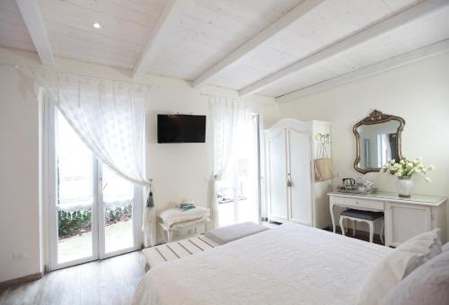 莱万托瓦伦蒂娜别墅酒店的白色的卧室设有床和窗户
