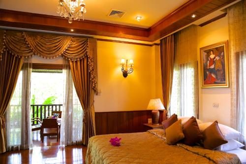 清迈Oriental Siam Resort - SHA Extra Plus Certified的一间卧室设有一张黄色墙壁的大床