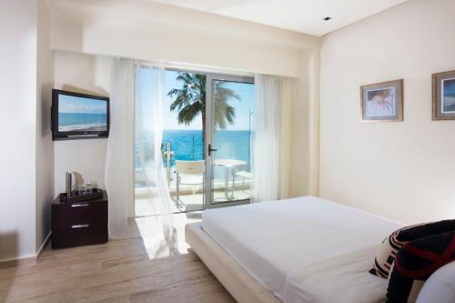 卡拉马塔伊利特城市度假酒店的一间卧室配有一张床,享有海景