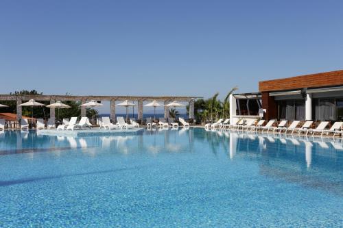 卡拉马塔伊利特城市度假酒店的一个带椅子和遮阳伞的大型游泳池