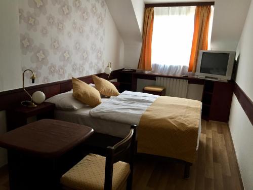 布达佩斯布达佩斯市中心格劳利亚酒店的酒店客房,配有床和电视