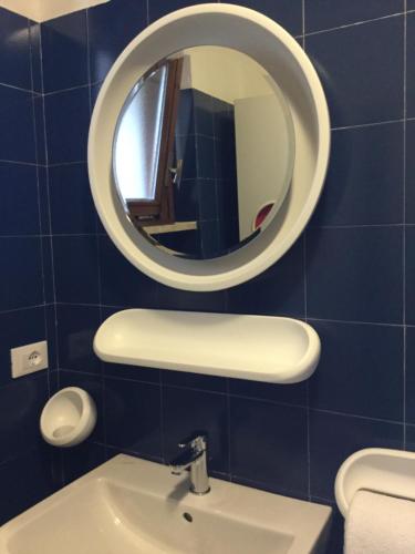 加尔达湖滨Appartamenti Garda il lago的一间带镜子和水槽的浴室