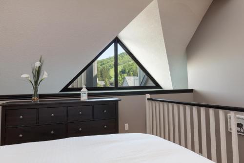 蓝山蓝山山畔复式公寓的一间卧室设有一张床和一个窗口