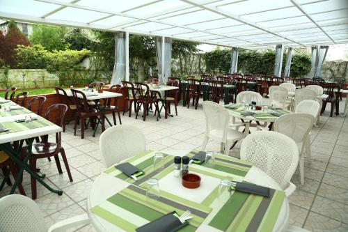 朗吉斯白房子餐厅酒店的庭院配有桌子和白色的桌椅