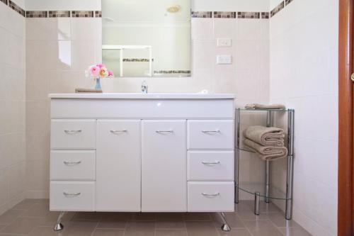 奥兰治Clifton Gardens Bed & Breakfast - Orange的白色的浴室设有水槽和镜子
