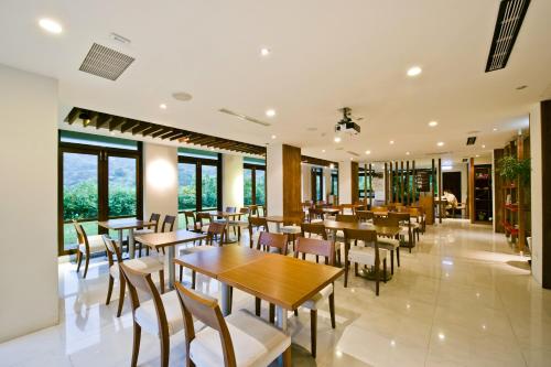 九份缓慢金瓜石 的餐厅设有木桌、椅子和窗户。