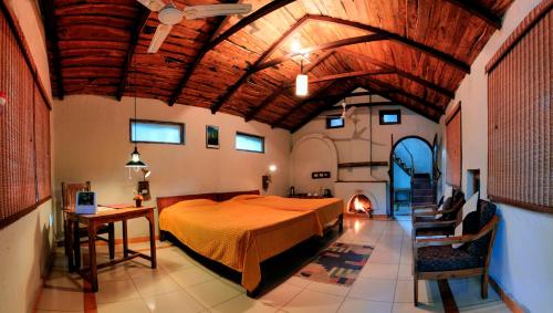 RājgarhKen River Lodge的一间卧室设有一张带木制天花板的大床