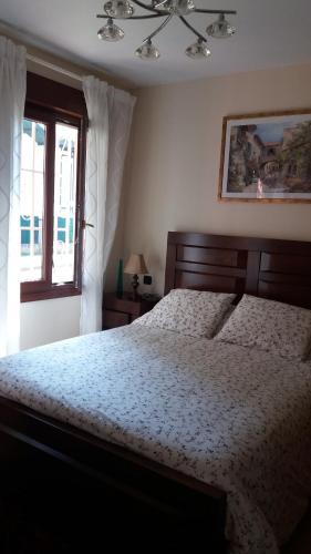 洛乌Apartamento Loiu的一间卧室设有一张大床和一个窗户。