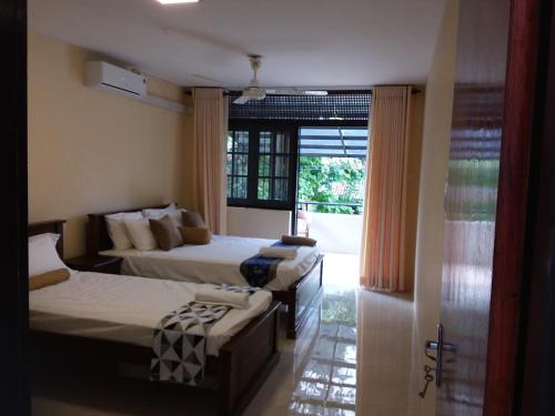 科伦坡科伦坡度假屋的酒店客房设有两张床和窗户。
