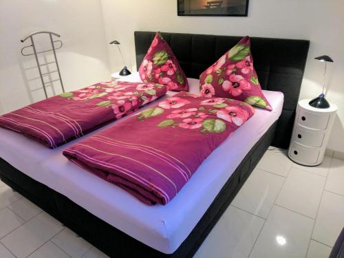 梅尔斯堡Ferienwohnung im Atelierhaus的一张带紫色和粉色床单及枕头的床