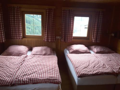 施图默尔贝格Steinwandhütte的带2扇窗户的客房内的2张床