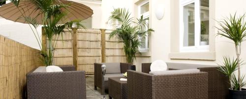 海德堡海德尔堡宾客之家酒店的一座带藤椅和棕榈树的庭院