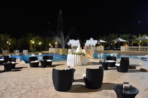 莱魁勒Tenuta Caradonna的一个带椅子的游泳池,晚上还有喷泉