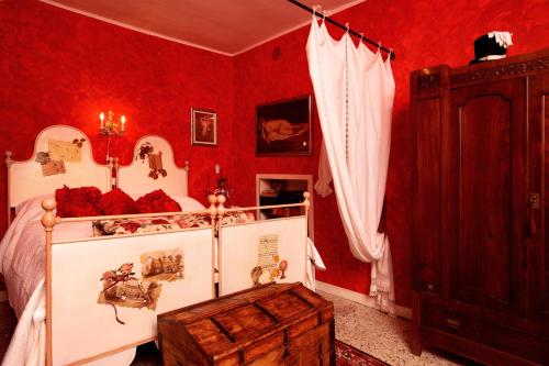 佩尔莱多C'era una Volta的一间卧室设有红色的墙壁和一张带木制槽的床