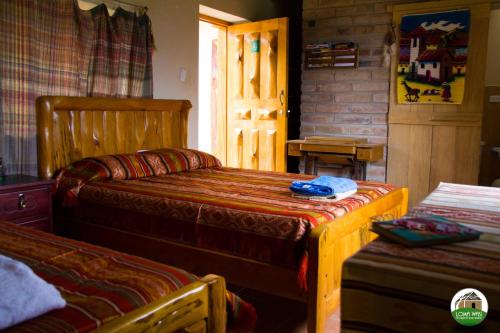 科塔卡奇Loma Wasi Alojamiento Rural Indígena en Cotacachi的一间卧室设有两张床,一扇门通往房间