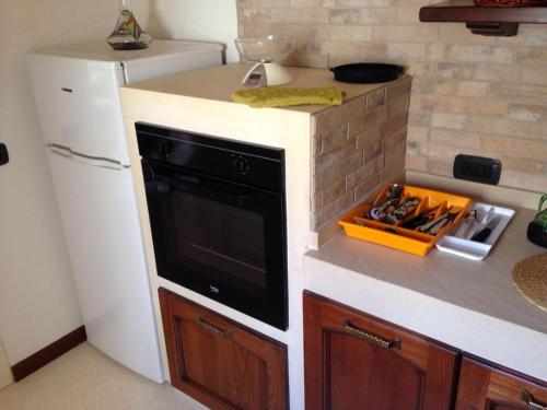 萨尔维Appartamento Libeccio的厨房配有黑烤箱和白色冰箱。