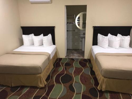 Piarco机场套房酒店的酒店客房带两张床和一间浴室