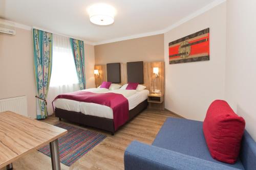 萨尔茨堡Hotel Das Junior by MAX 70的酒店客房设有两张床和一张桌子。