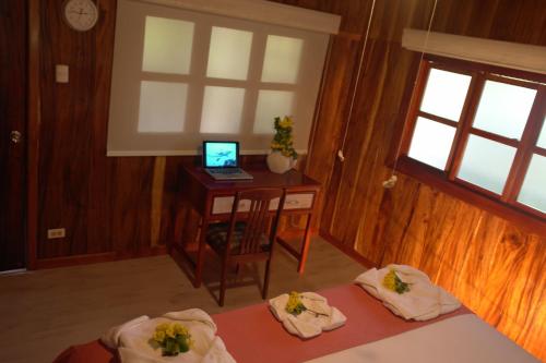 比亚米尔港木屋酒店的一间卧室配有两张床和一张带电脑的书桌