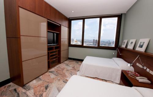 巴拿马城黎明之塔酒店及套房的酒店客房设有两张床和电视。