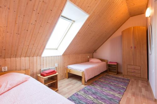 KassariVetsi Talli Holiday Village的阁楼卧室设有两张床和窗户。