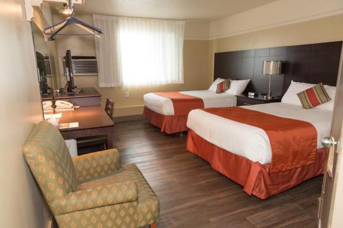 Saint-Joseph-de-Beauce鲁何奈尔餐厅及酒吧酒店的酒店客房,配有两张床和椅子