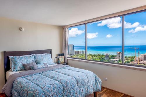 檀香山Hawaiian Monarch Penthouse 402的一间卧室设有一张床,享有海景