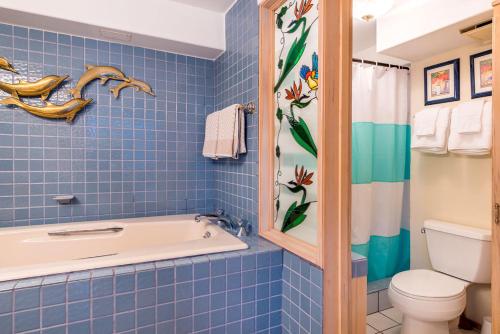 檀香山Hawaiian Monarch Penthouse 402的蓝色瓷砖浴室设有浴缸和卫生间