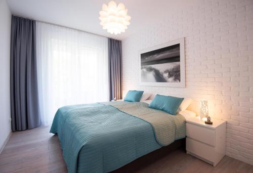 科沃布热格LATO apartament Solna 11c z garażem的一间卧室配有一张床和一个吊灯