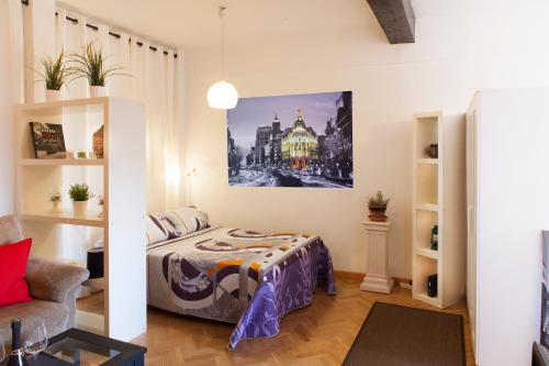 马德里塞戈维亚公寓的卧室配有一张床,墙上挂有绘画作品