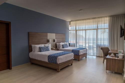 马萨特兰Ocean View Beach Hotel的一间卧室设有两张床和大窗户