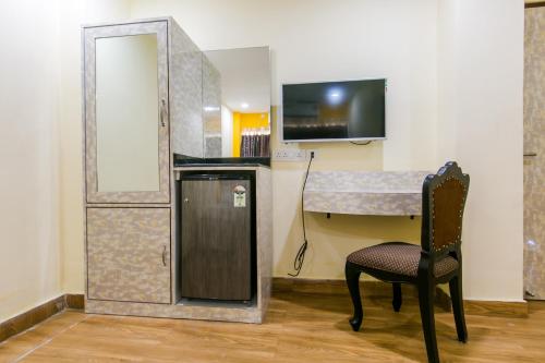 加尔各答Hotel Platinum的客房设有书桌、椅子和镜子